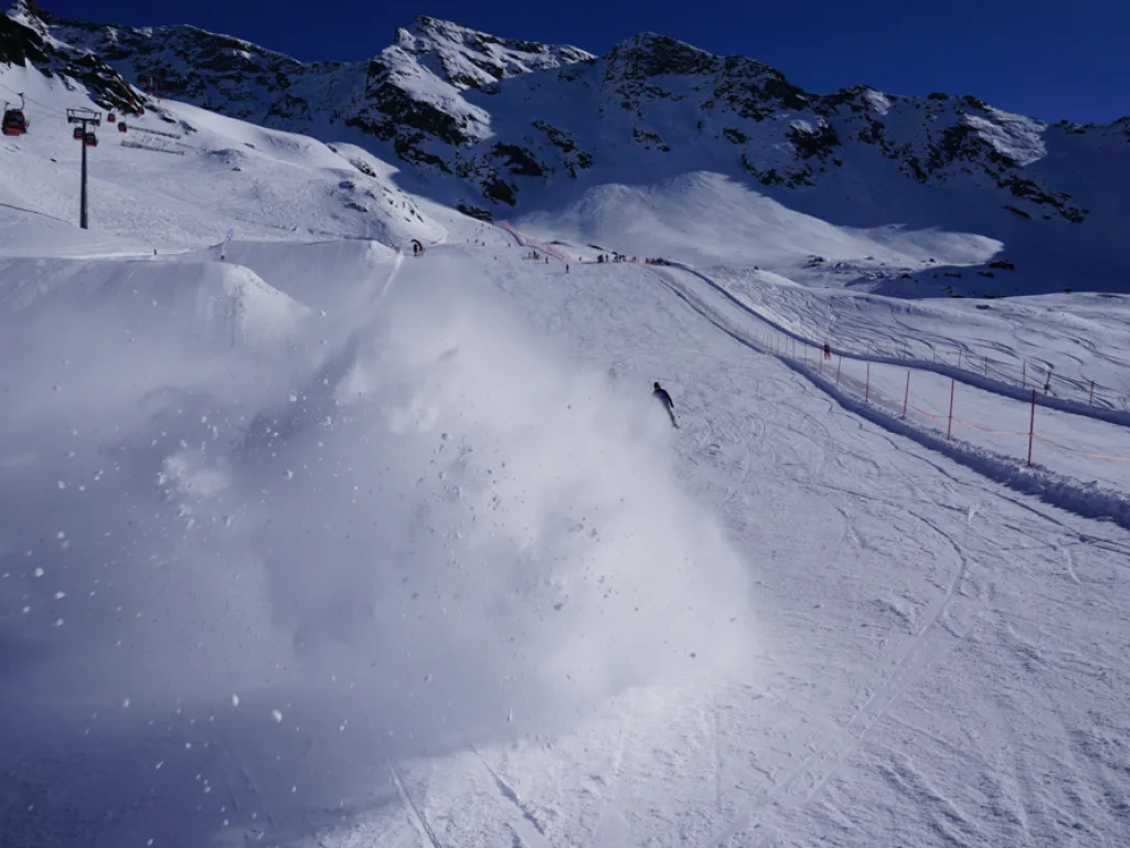 Skifahrer verschwindet fast in der Schneewolke.